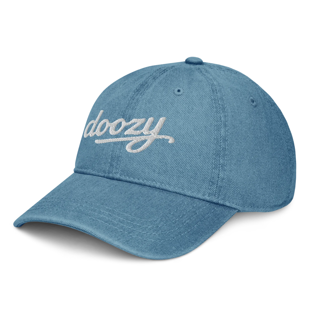 Gorra denim azul Doozy Headwear con logo bordado blanco, vista lateral izquierda