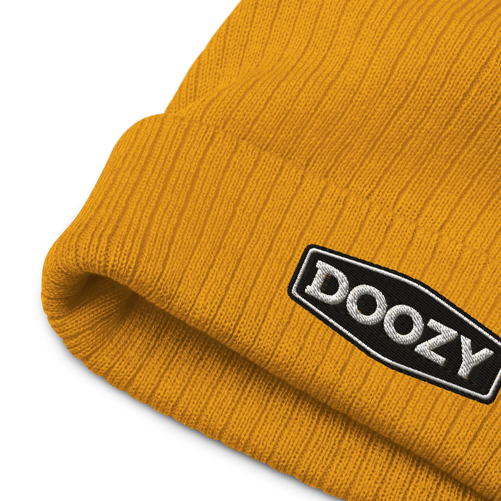 Gorro de punto canalé mostaza Doozy Headwear con logo bordado en negro y blanco.